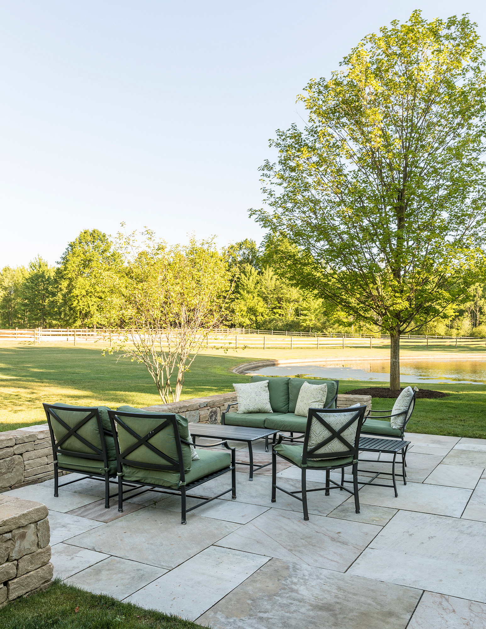 A side terrace is paved with large-scale local stone and enclosed by a low stone seat wall. A specimen Maple will provide shade while Serviceberries provide early spring flowers and a loose edge to the space.